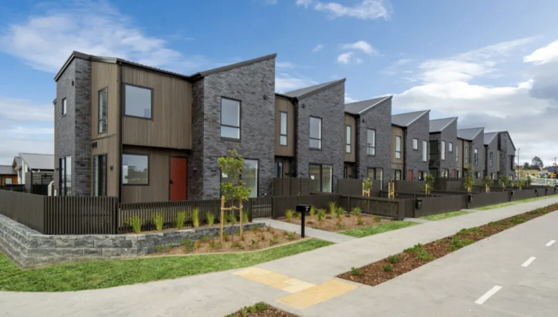 An exterior shot of the row of townhouses from the left hand side, facing from the road.